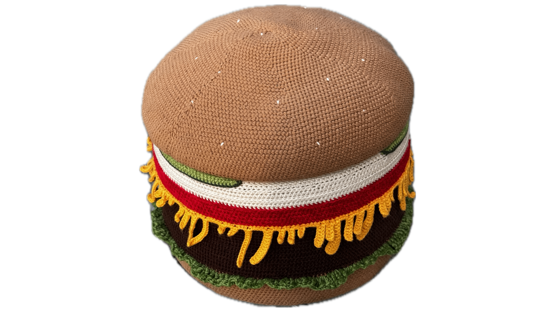 A full sized crocheted burger ottoman shaped like a cheeseburger, with a sesame bun, lettuce, tomato, cheese, and a beef patty.